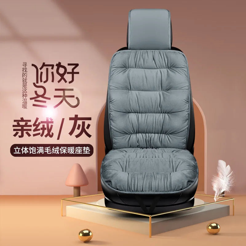 A gray plush car seat cover with a padded backrest is displayed on a wooden platform.