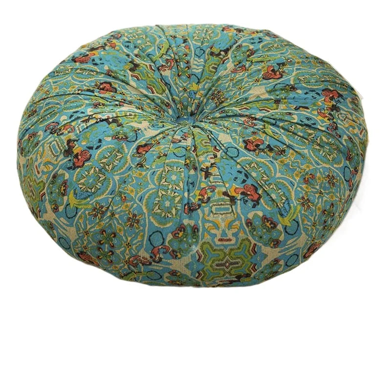 A round floor cushion covered in a blue and green bohemian cotton linen fabric with intricate patterns.