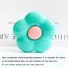A light blue flower-shaped phone grip stand with small black dots on the surface.