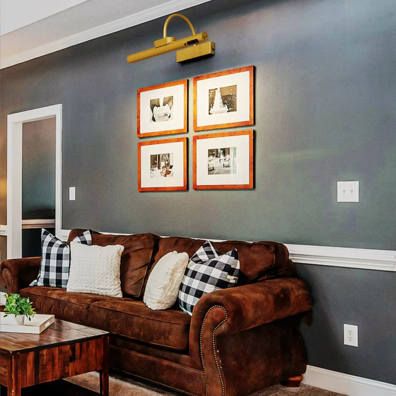 A dark brown leather sofa in a modern living room with framed pictures on the gray wall.