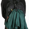 A dark green durable polyester luggage strap with an ID tag is draped over a black backpack.