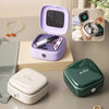 A purple compact magnetic sewing kit with needles and thread colors is displayed on a light wooden surface.