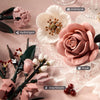 A collection of pink rose and anemone building blocks arranged on a pink fabric with dried berries.