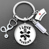 Silver necklace keychain featuring a glass dome charm with the text I LOVE NURSING and a medical syringe charm.