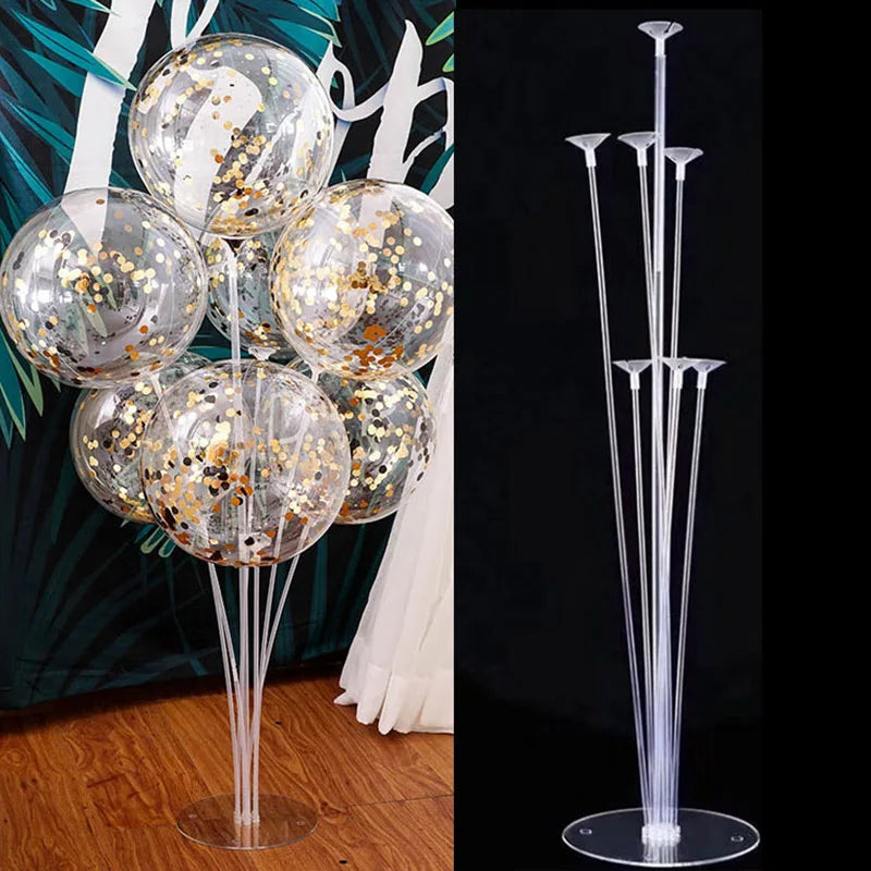 Clear plastic balloon column stands with gold confetti balloons displayed against a dark background.