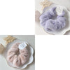 A close-up of a lavender plush coil hair tie resting on a white plate, with a gold star decoration nearby.