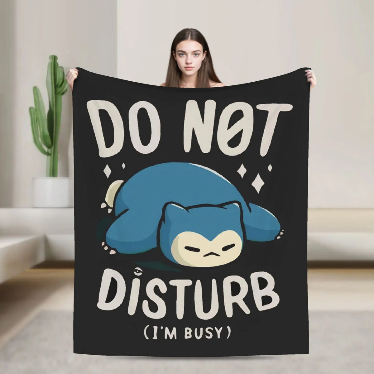 A black blanket featuring a cartoon blue Snorlax character with the text DO NOT DISTURB I'M BUSY