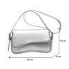 Silver vintage leather crossbody bag with a flap closure shown from the side.