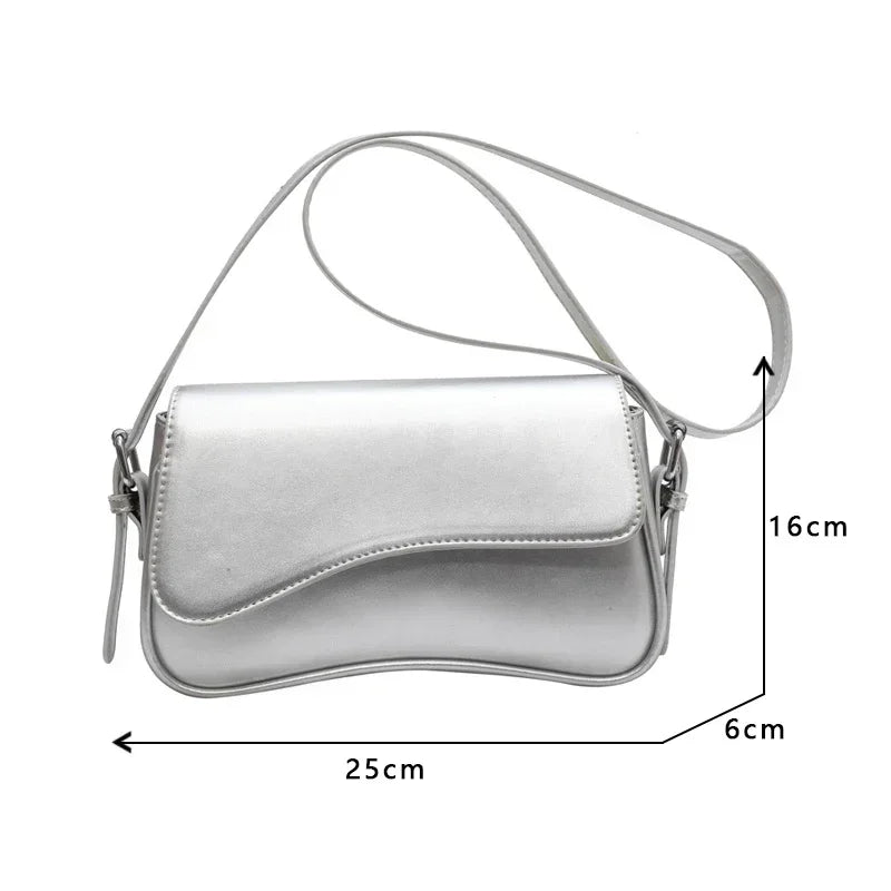 Silver vintage leather crossbody bag with a flap closure shown from the side.