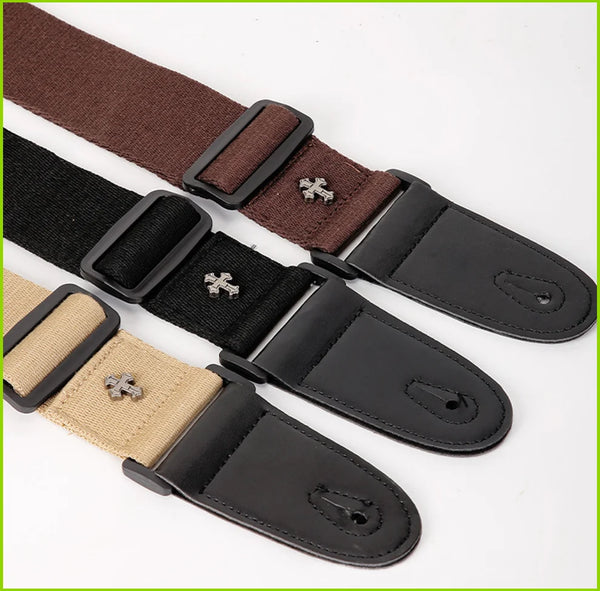 A set of vintage cross pattern guitar straps in brown, black, and tan leather with pick pockets.