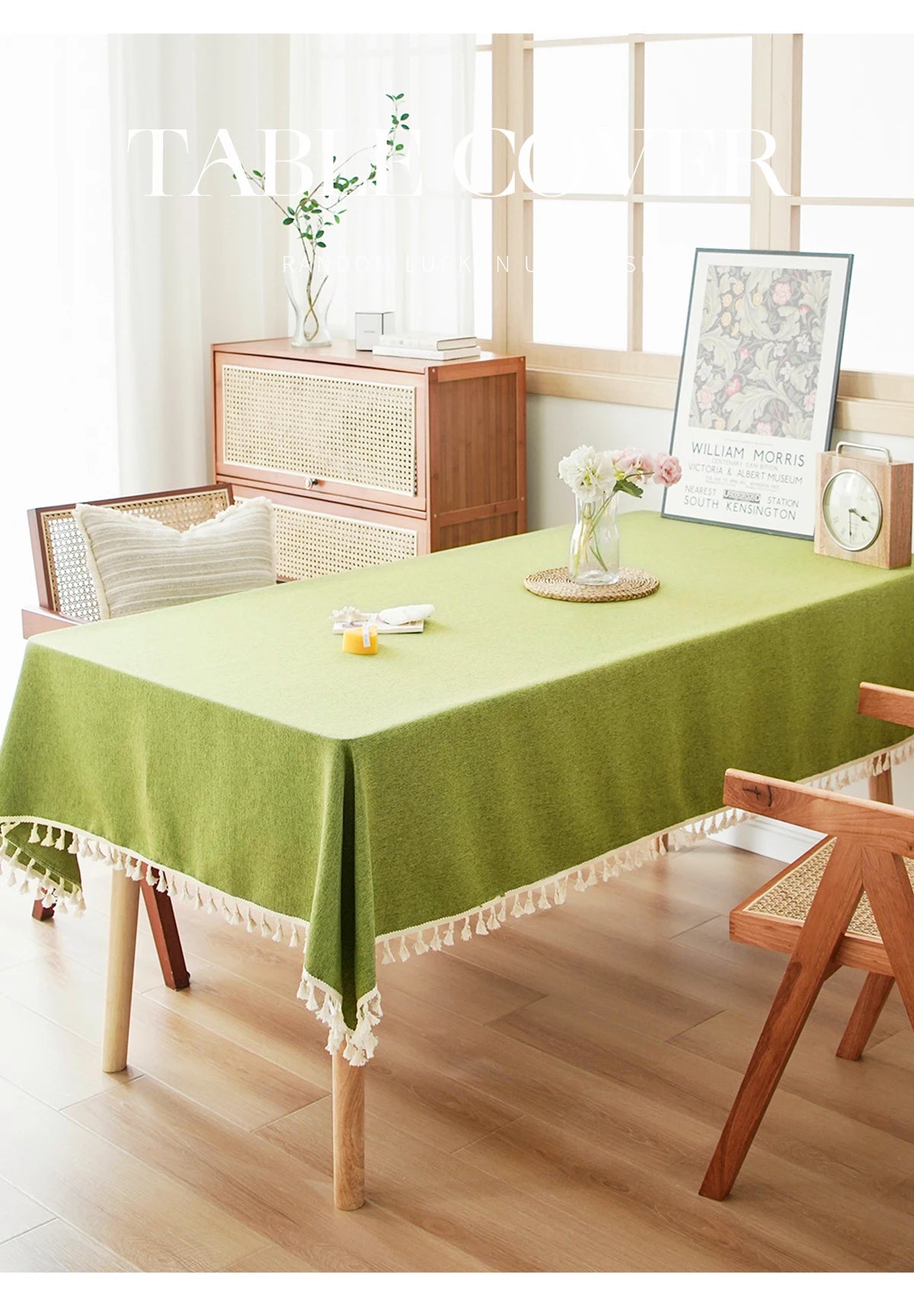 A lime green farmhouse tablecloth with white cotton tassels is displayed on a wooden dining table.