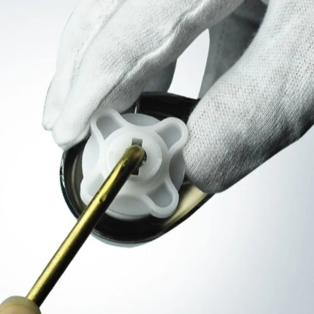 A hand wearing a white glove is operating a brass toilet tank flush lever with a side mount design.
