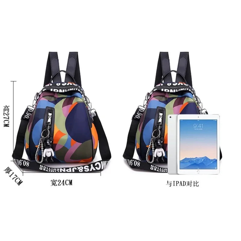 A compact oxford backpack tote in multi-colored floral print with black trim and strap details.