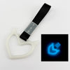 A white heart-shaped car handle decor with a black strap and holographic finish.