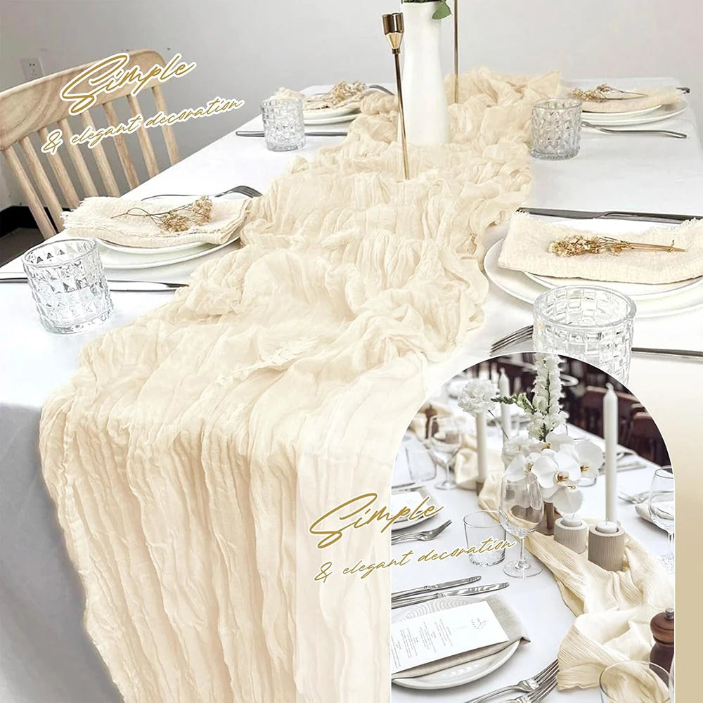 A long, sheer beige gauze table runner with ruffled edges is displayed on a white tablecloth.