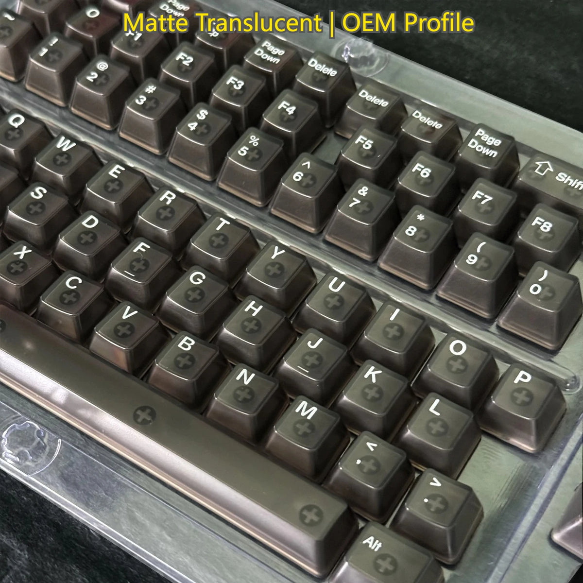 Close-up view of dark brown translucent keycaps for a mechanical keyboard showing various letter and function keys.