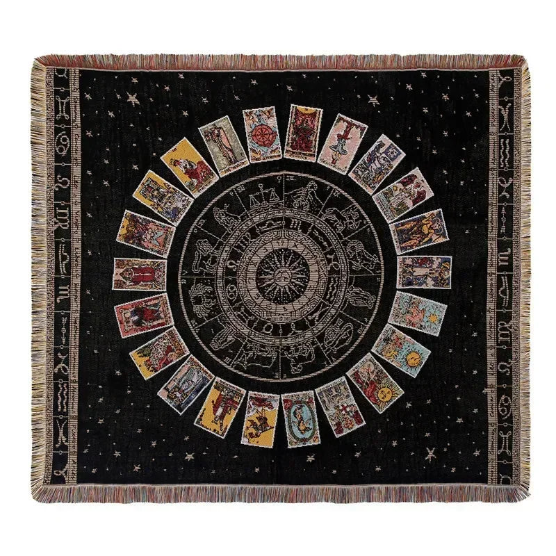 A dark woven throw blanket featuring a central sunburst design with radiating panels and fringed edges.