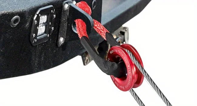 Close-up of a synthetic winch rope soft shackle and recovery ring kit attached to a black metal bracket.