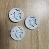 Four white silicone molds shaped like butterflies are arranged on a wooden surface.