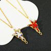 Gold crystal pendant necklace featuring a red gemstone and a clear star design on a white background.