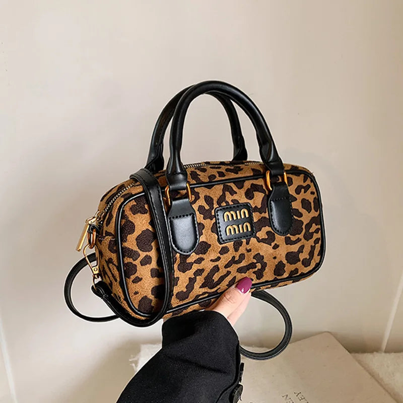 A brown and black leopard print retro hobo satchel bag with black leather handles and gold hardware.
