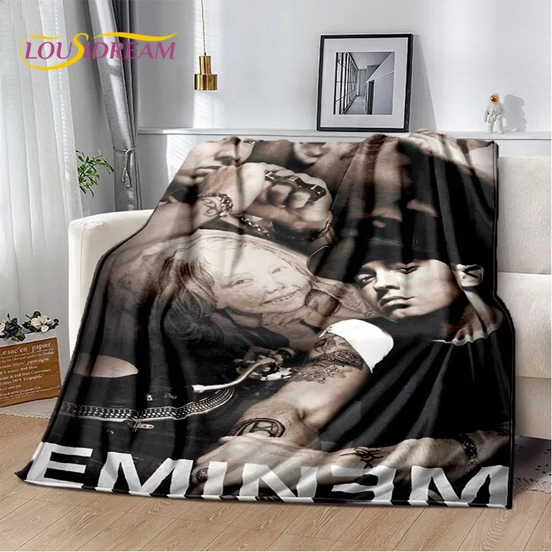 A dark photographic print of Eminem and 2Pac featuring their faces and hands, displayed as a throw blanket.