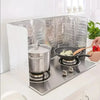 A foldable aluminum stove splatter guard is placed on a stovetop with a pot cooking on it.