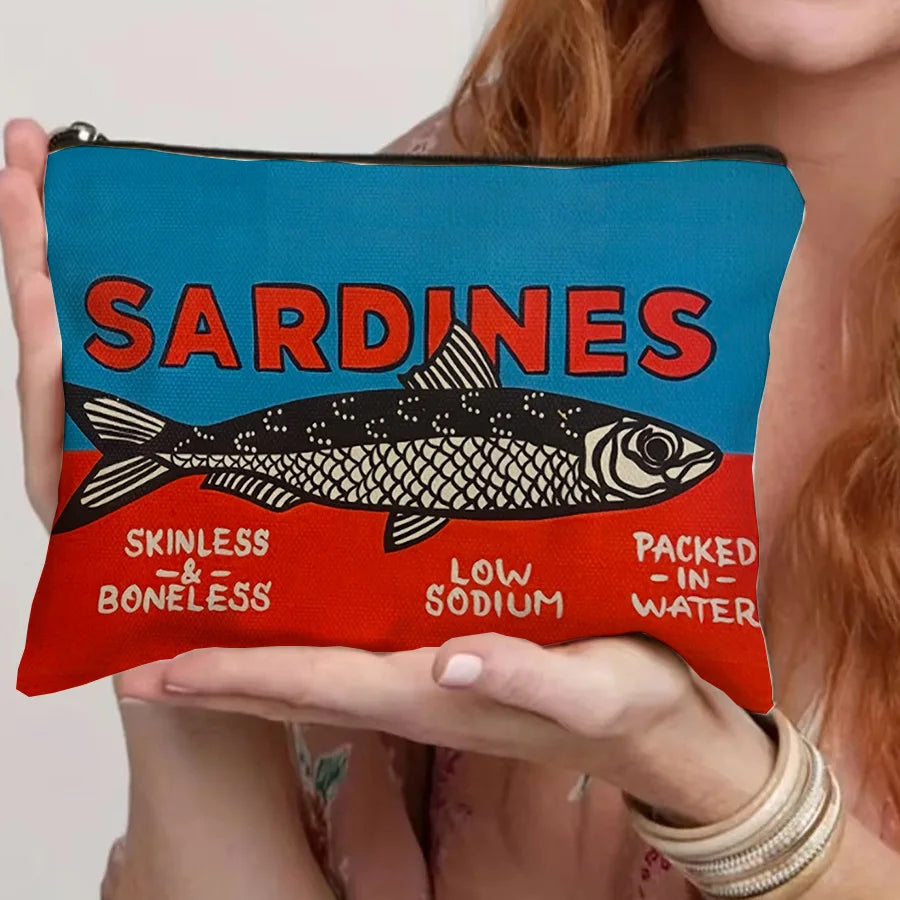 A teal cosmetic bag with a black and red sardine print featuring the text Sardines Skinless Boneless Low Sodium Packed In Wat