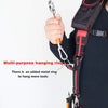 A hand is holding a multi-purpose hanging ring attached to a tool belt strap.