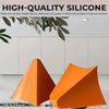 Two orange silicone tile grout filling tools resting on a glass surface.