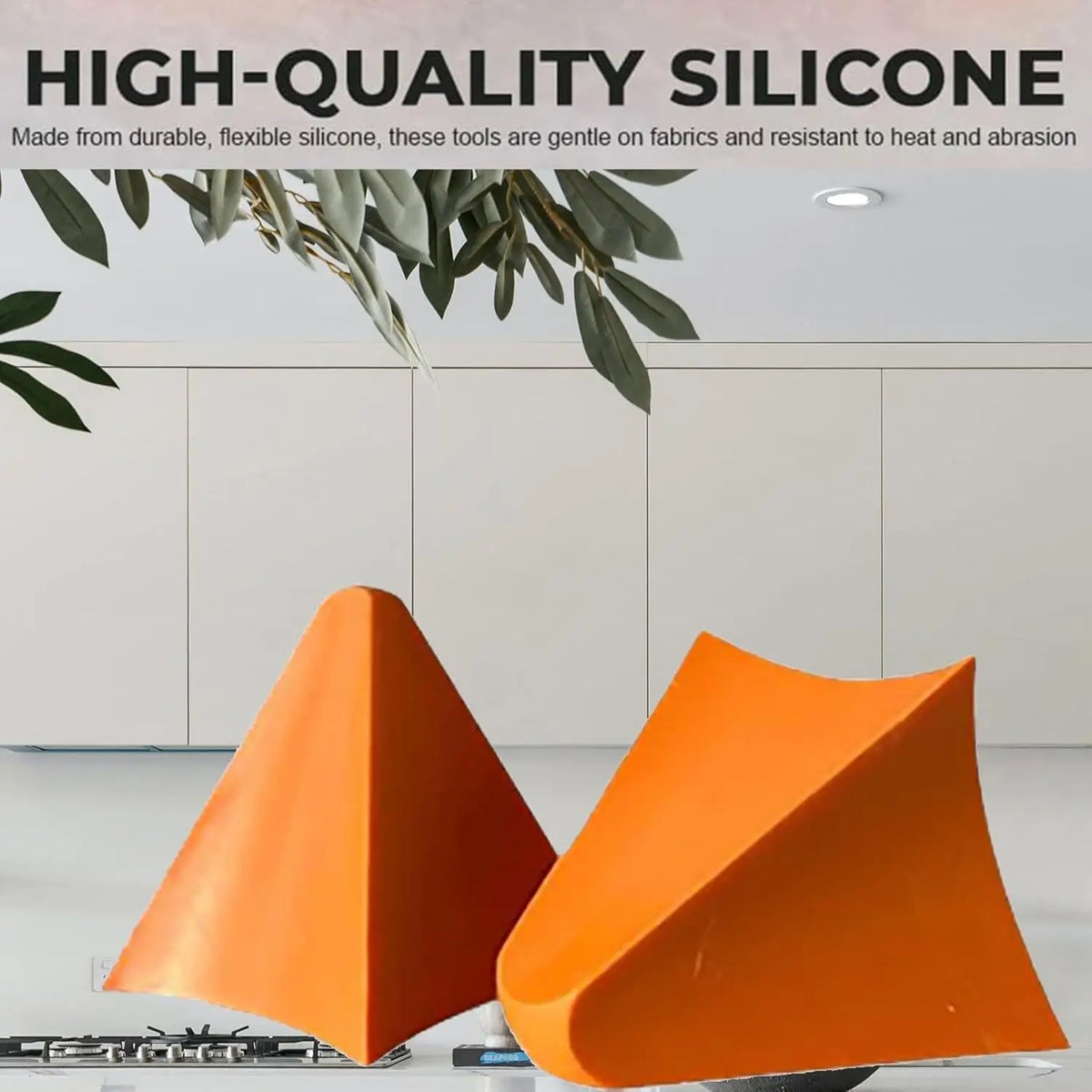 Two orange silicone tile grout filling tools resting on a glass surface.