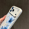 A white magnetic phone case featuring a blue lily floral design on the back, held by a hand against a dark background.