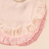 A set of three soft cotton ruffle bibs in shades of pink and mauve.