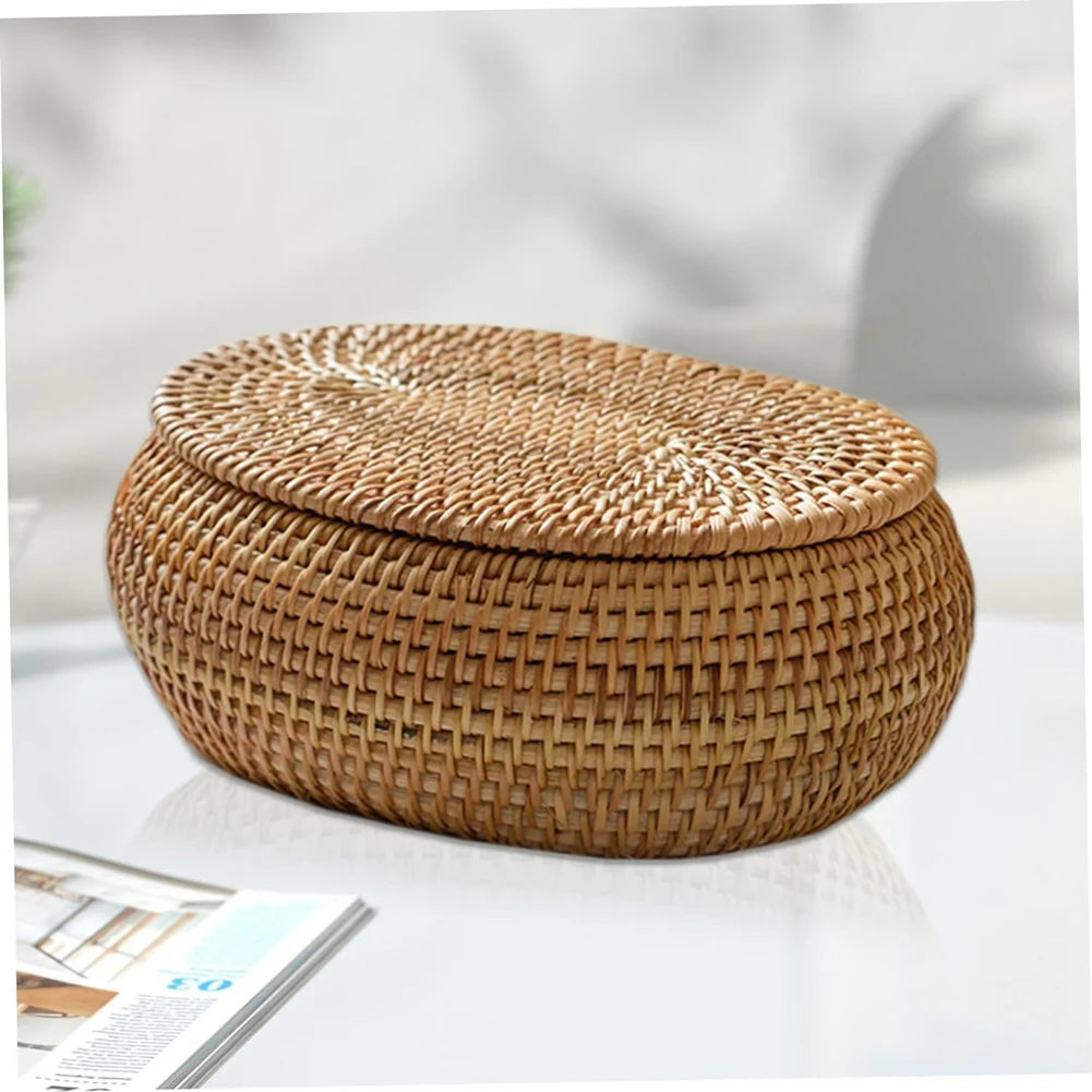 A round, woven rattan storage basket with a matching lid resting on a white surface.