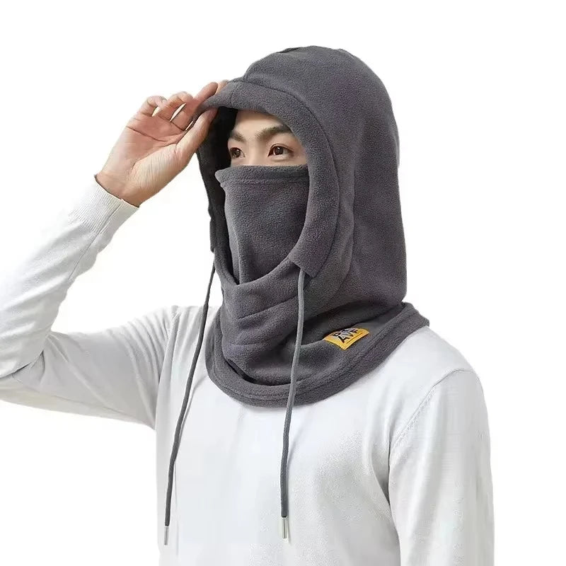 A person wearing a gray 3-in-1 winter balaclava with a mask and neck warmer, pulled up over their face.