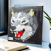 A framed mosaic wall art kit depicting a fierce wolf head made of black and white building blocks.