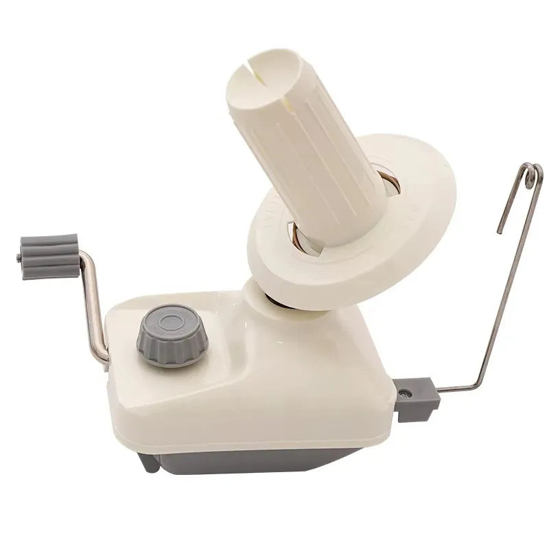 A compact hand-operated yarn ball winder for knitting and crochet, featuring a white plastic body and a cylindrical winding m