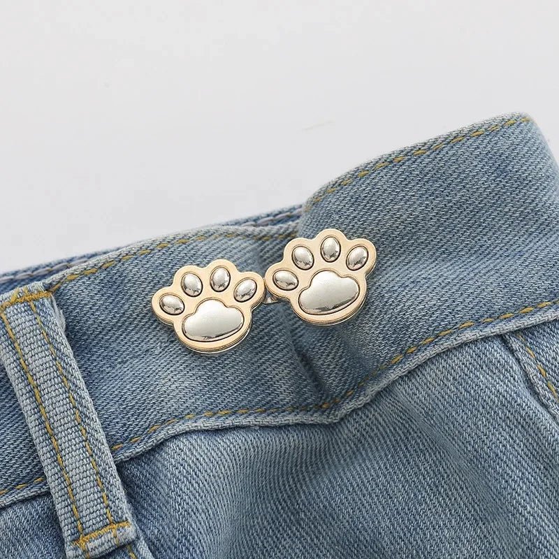 Accessoire bouton empreinte de patte argentée attaché au tissu en denim