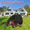 A red heavy-duty yard tractor with a black waterproof cover is parked on a green lawn in front of a house.