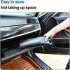 A hand is opening a black foldable car windshield sunshade umbrella inside a car.