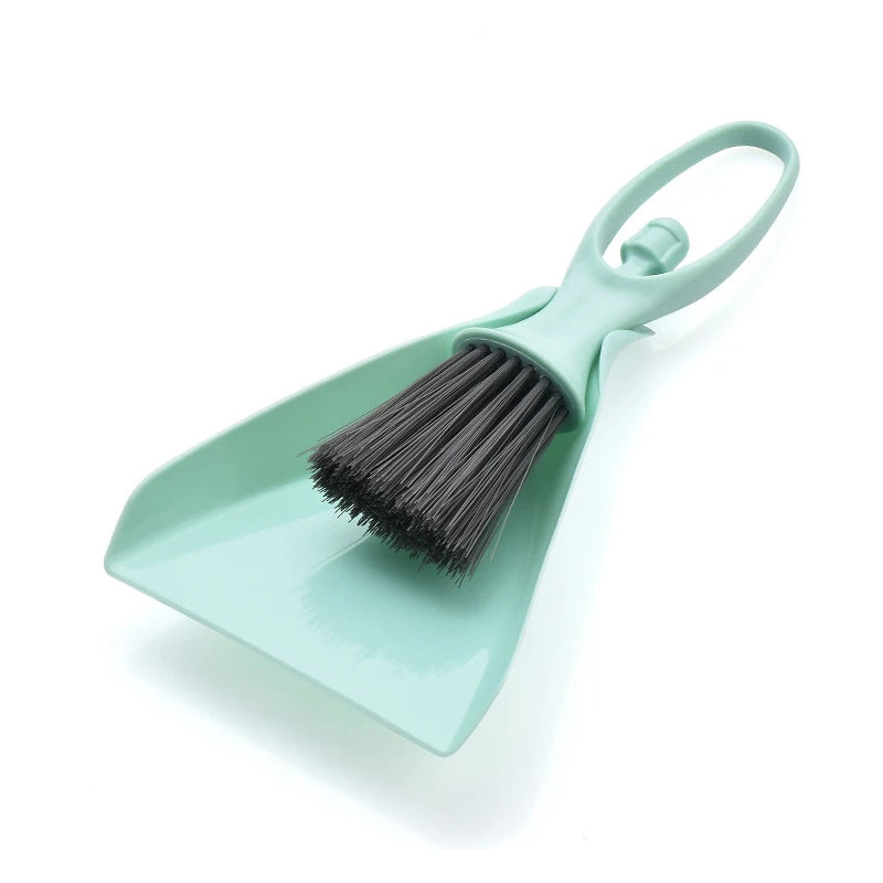 A light mint green compact mini broom and dustpan set for cleaning desks and keyboards.