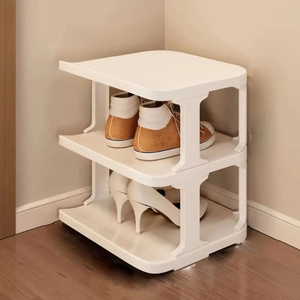 A white stackable vertical shoe rack with two tiers holding pairs of brown leather shoes.