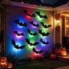 A wall decorated with glowing black bat silhouettes illuminated by multi-colored LED lights for Halloween