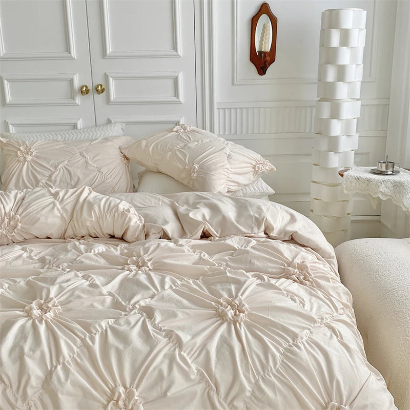 A light pink luxury duvet cover set featuring a 3D twist floral pinch-pleated pattern on a bed.