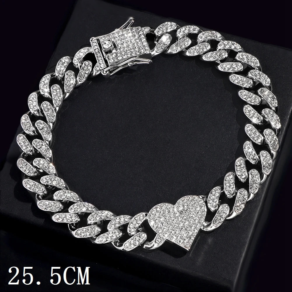 A silver iced-out Cuban link bracelet featuring a heart charm displayed on a black background.