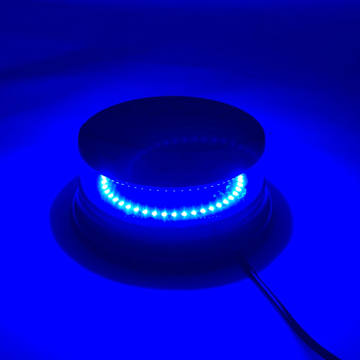 A magnetic mount LED emergency strobe light with a blue light illuminating the underside against a dark blue background.