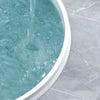 A close-up view of a light blue shower with water flowing, set in a modern bathroom.