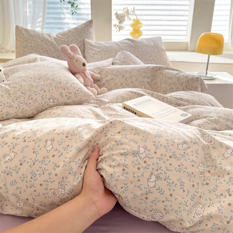 A beige duvet cover set featuring a cute dog print pattern with small floral elements, displayed on a bed.