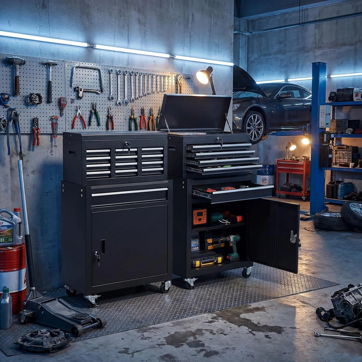 A dark gray rolling tool cabinet with a black tool chest and various tools stored inside in an industrial workshop.