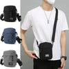 A person wearing a white t-shirt is holding a black mini crossbody phone bag with an adjustable strap.